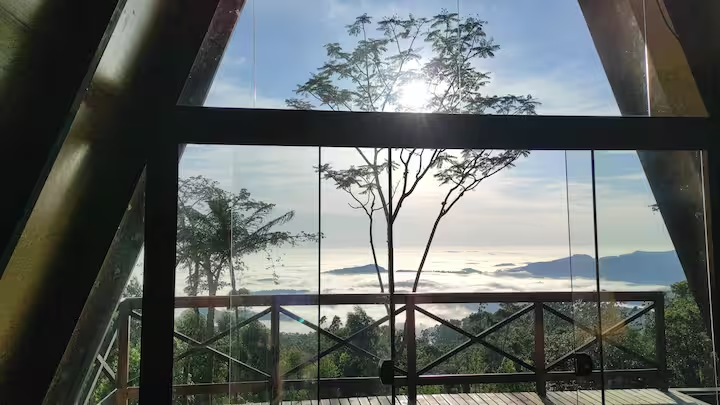 Vista da janela do chalé sobre o mar de nuvens